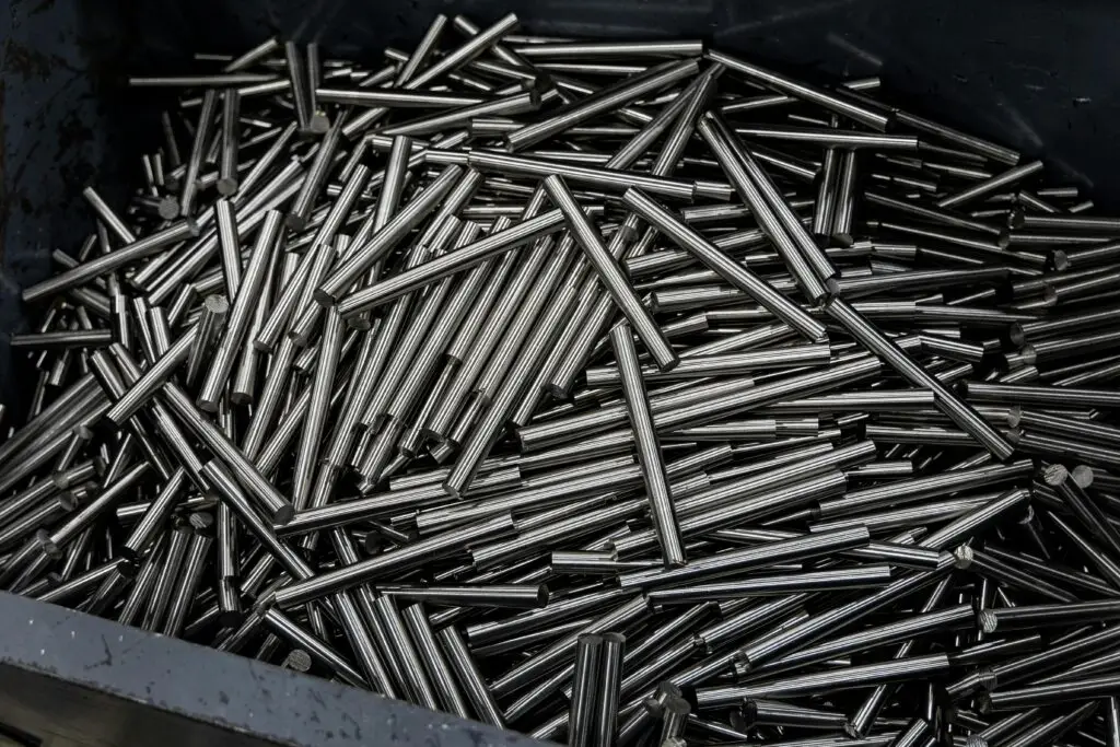 Close-up of numerous stainless steel rods in a container, showcasing industrial metal texture.